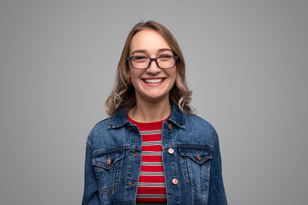 young girl in a denim jacket smiles