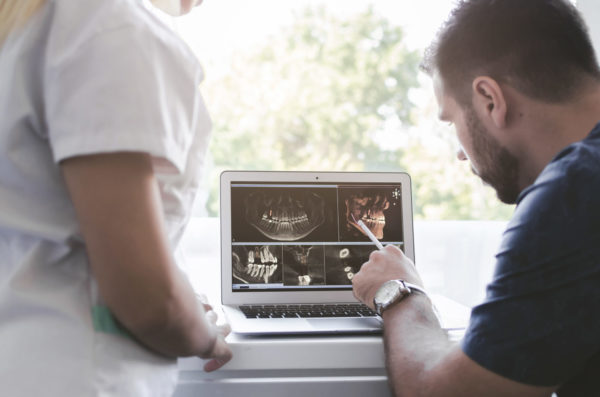 Male and female dentist looking at xray