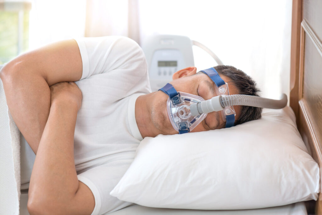 Man sleeping in bed wearing CPAP mask ,sleep apnea therapyHappy